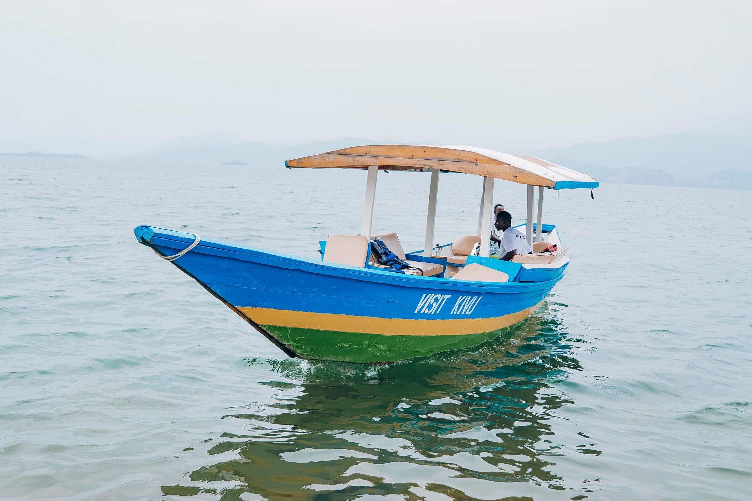 A Visit Kivu passenger boat at rest on the calm water of Lake Kivu